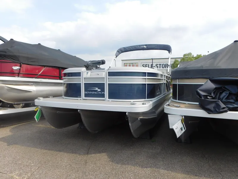Slide: The Image of 2023 Bennington 22SXSR pontoon boat in storage lot, front view. - 1