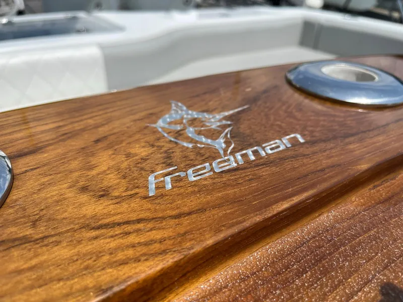 Slide: The Image of Close-up of Freeman 37 VH 2021 boat's wooden deck with logo. - 12