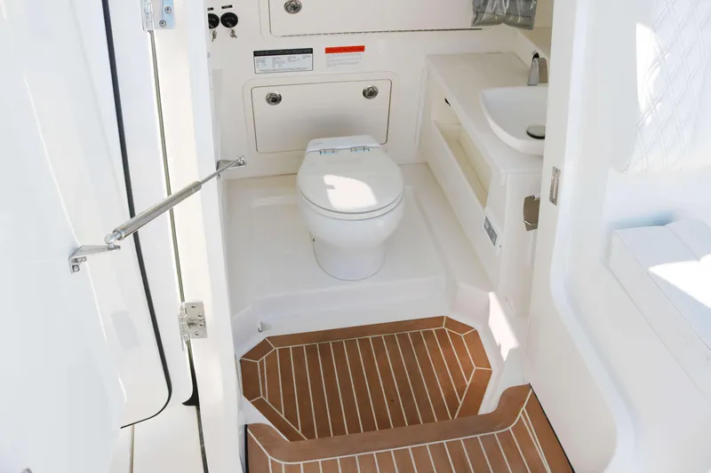 Slide: The Image of 2023 World Cat 400 CC-X boat bathroom with toilet, sink, and wooden floor. - 10