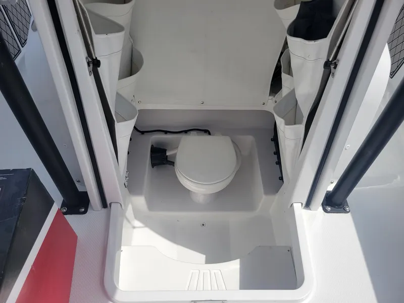 Slide: The Image of 2024 Wellcraft 222 Fisherman boat interior with a compact marine toilet. - 15