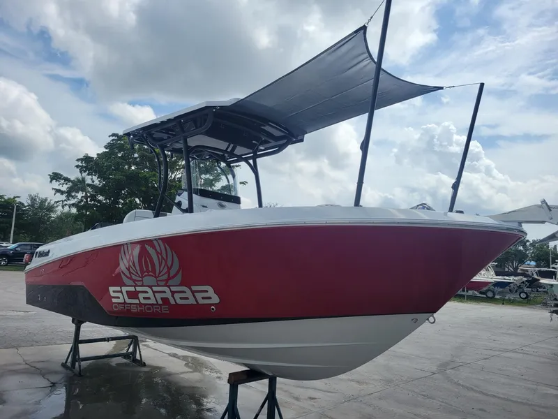 Slide: The Image of 2024 Wellcraft 222 Fisherman boat with red hull and Scarab Offshore branding. - 3