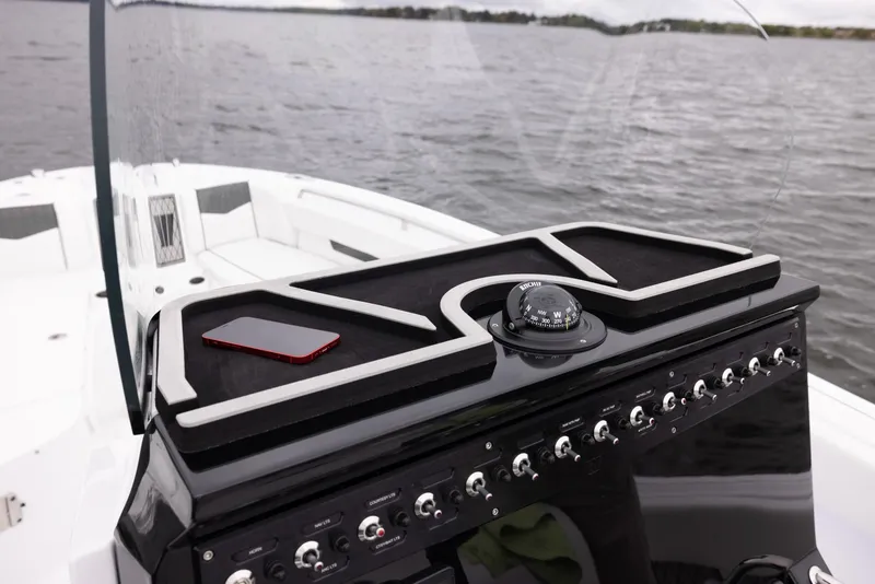 Slide: The Image of 2024 Wellcraft 222 Fisherman boat console with navigation instruments on a calm lake. - 34
