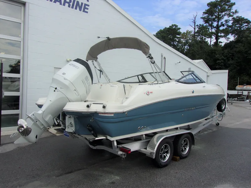 Slide: The Image of 2023 Stingray 231 DC boat on trailer outside building. - 13