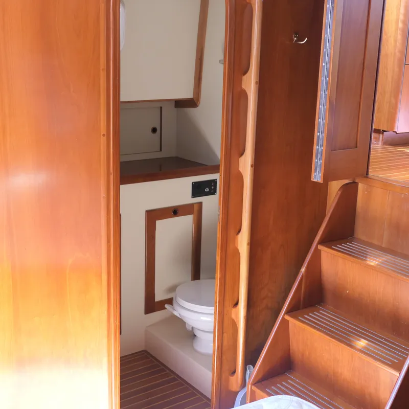 Slide: The Image of Interior of 2020 Alden Motor Yacht showing wooden stairs and compact bathroom. - 28