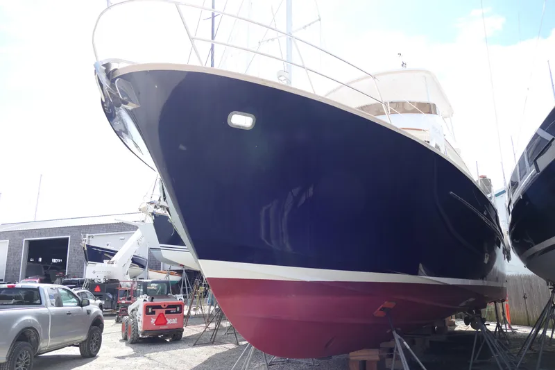 Slide: The Image of 2020 Alden Motor Yacht in dry dock, blue hull, red bottom, marina setting. - 6