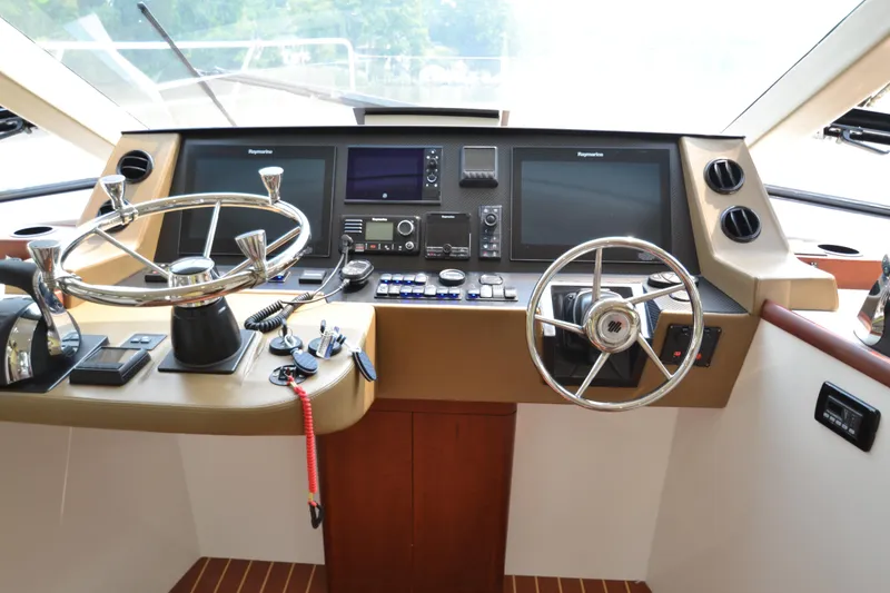 Slide: The Image of ArrowCat 42 Coupe 2022 helm station with dual steering wheels and advanced navigation systems. - 10