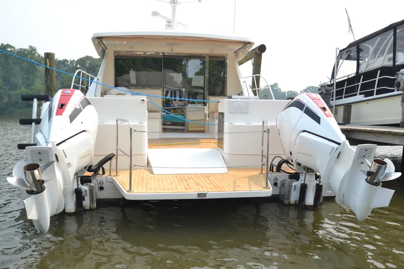 Slide: The Image of 2022 ArrowCat 42 Coupe boat with twin outboard engines docked. - 3