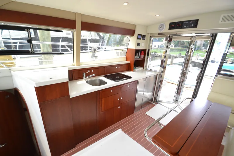 Slide: The Image of 2022 ArrowCat 42 Coupe yacht interior kitchen with modern appliances and wooden cabinetry. - 7