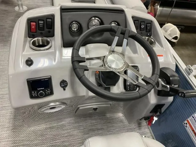 Slide: The Image of 2024 Bennington 218 SL boat dashboard with steering wheel, gauges, and control panel. - 10