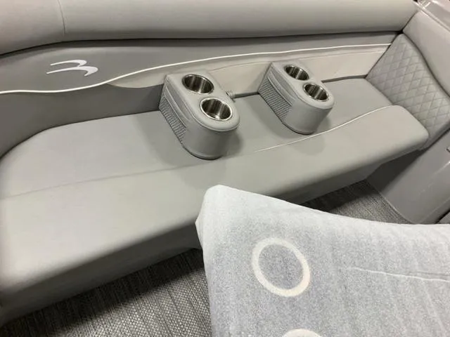 Slide: The Image of 2024 Bennington 218 SL boat interior with gray seating and dual cup holders. - 13