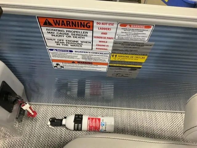 Slide: The Image of Warning labels and fire extinguisher on a 2024 Bennington 218 SL boat. - 9