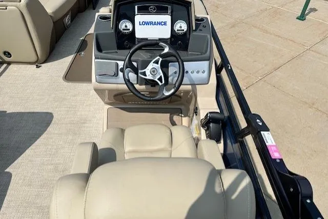 Slide: The Image of 2023 Regency 250 DL3 boat dashboard with Lowrance navigation system and beige seating. - 7