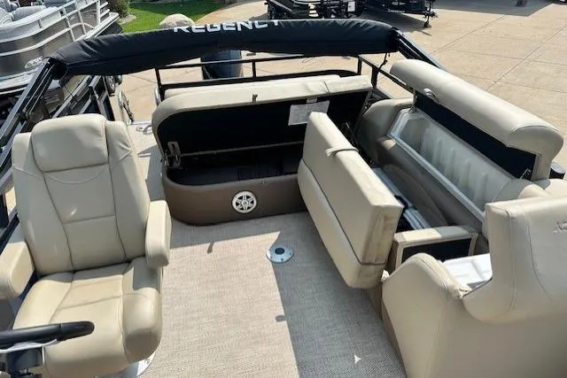 Slide: The Image of 2023 Regency 250 DL3 pontoon boat interior with beige seating and storage compartments. - 8
