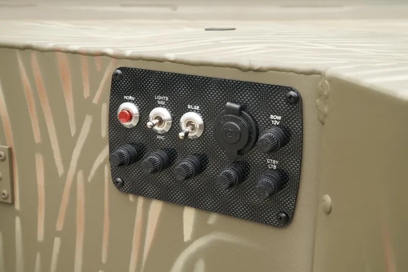 Slide: The Image of Control panel of 2023 Tracker Grizzly 1654 T Sportsman boat with switches and outlets. - 23