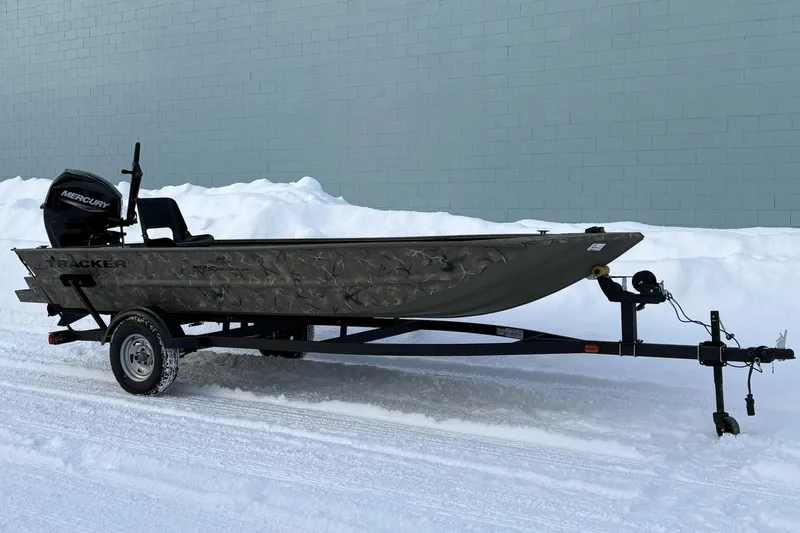 Slide: The Image of 2023 Tracker Grizzly 1654 T Sportsman boat on snowy ground with trailer. - 5
