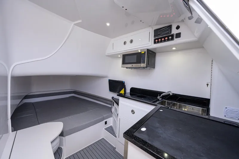 Slide: The Image of Interior of 2025 Contender 39FA boat with kitchenette, microwave, and sleeping area. - 14