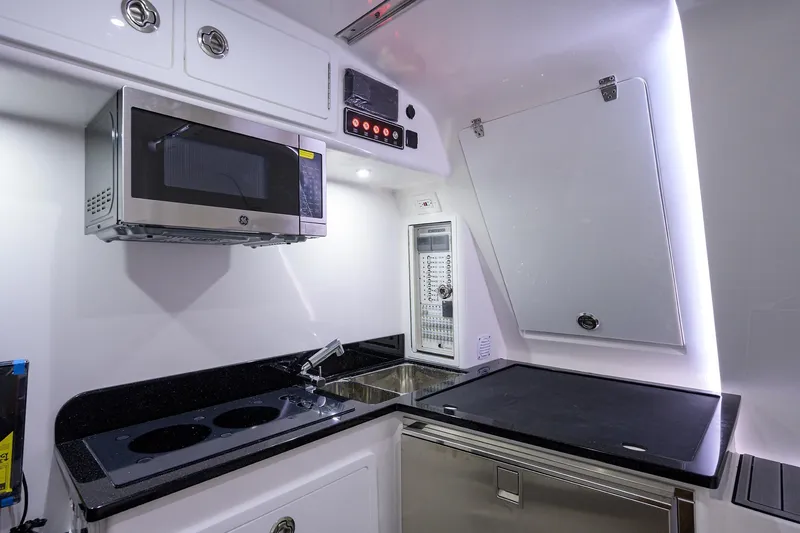 Slide: The Image of Modern kitchen area in 2025 Contender 39FA boat with microwave, stove, and sink. - 17
