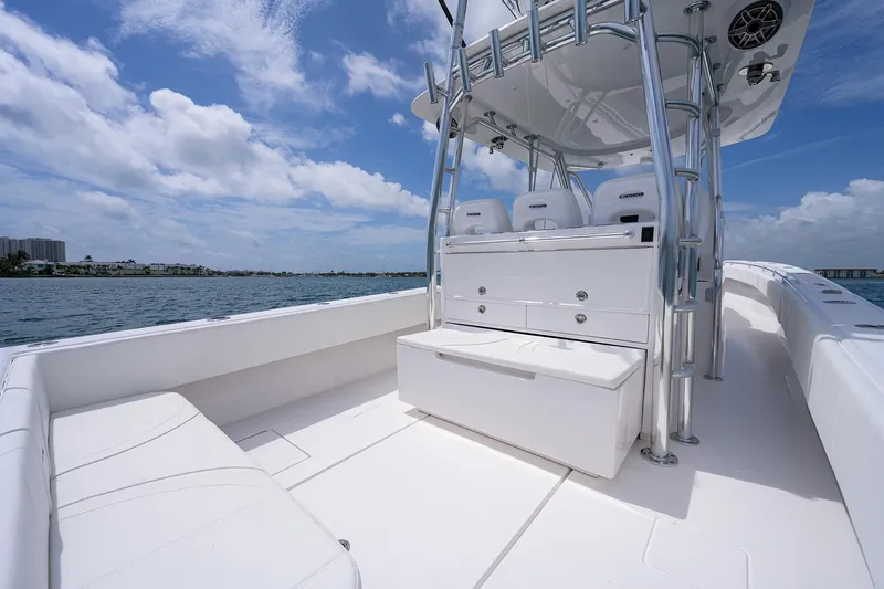 Slide: The Image of Contender 39FA 2025 model boat interior with seating and storage, cruising on a sunny day. - 23