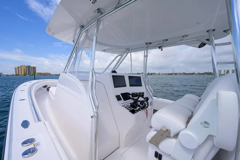 Slide: The Image of Contender 39FA 2025 model boat interior with dual screens and white seating on open water. - 26