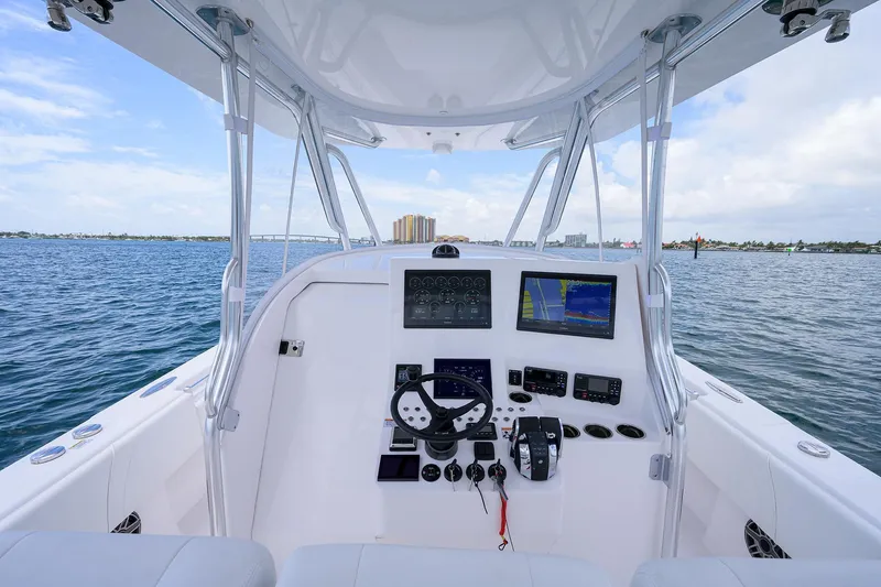 Slide: The Image of Contender 39FA 2025 boat dashboard with navigation screens and steering wheel on open water. - 27