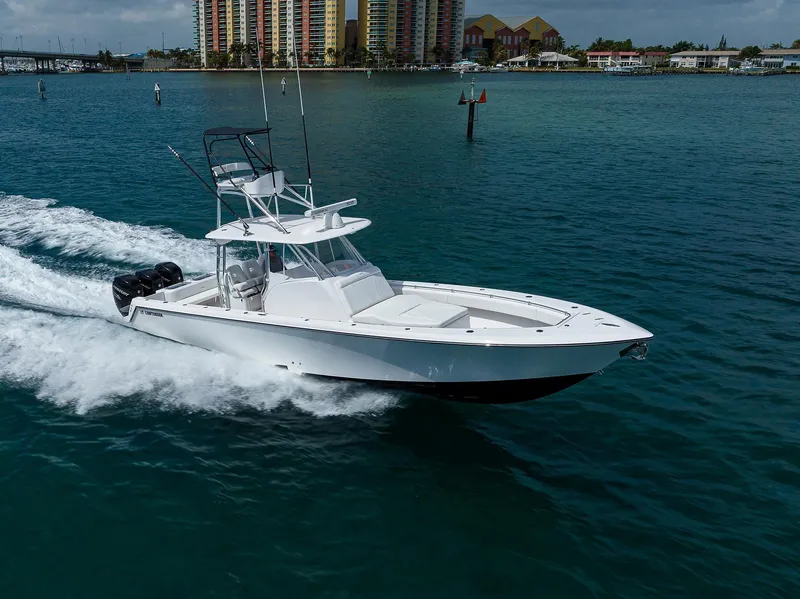 Slide: The Image of Contender 39FA 2025 model boat cruising on water near coastal buildings. - 8