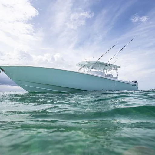 Slide: The Image of 2025 Contender 44FA boat on clear ocean water under a bright sky. - 12