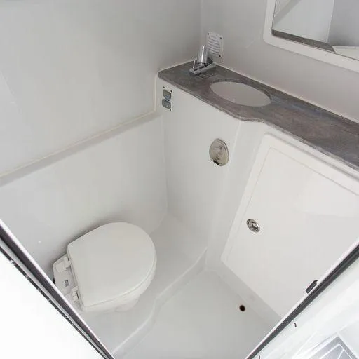Slide: The Image of Compact bathroom in 2025 Contender 44FA boat with toilet, sink, and storage. - 21
