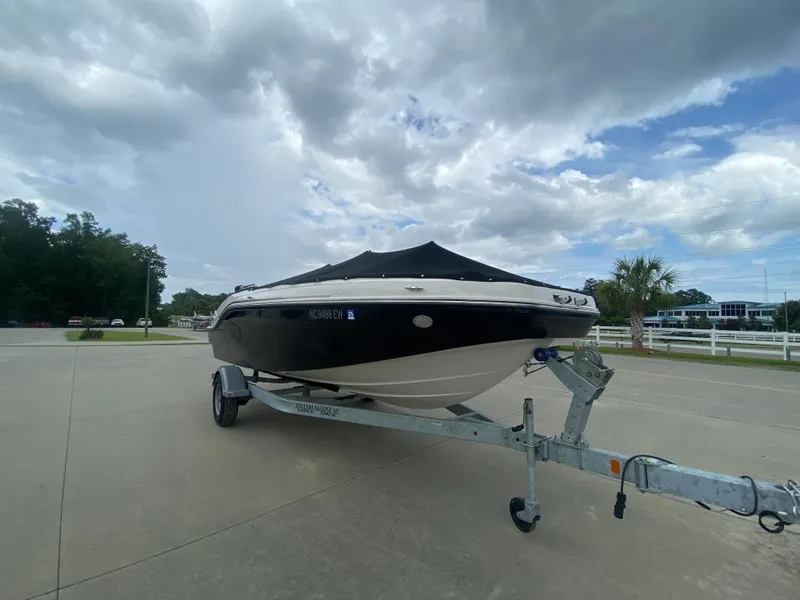 Slide: The Image of 2022 Bayliner DX2000 boat on a trailer under a cloudy sky. - 6