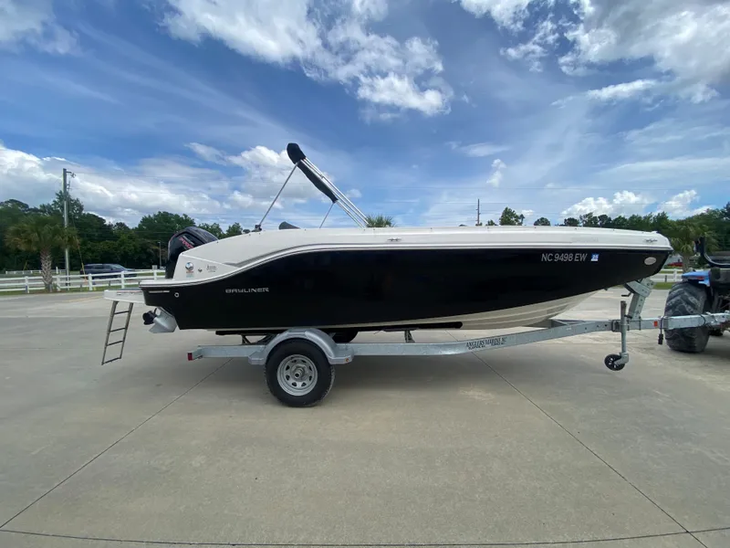 Slide: The Image of 2022 Bayliner DX2000 boat on a trailer under a partly cloudy sky. - 1