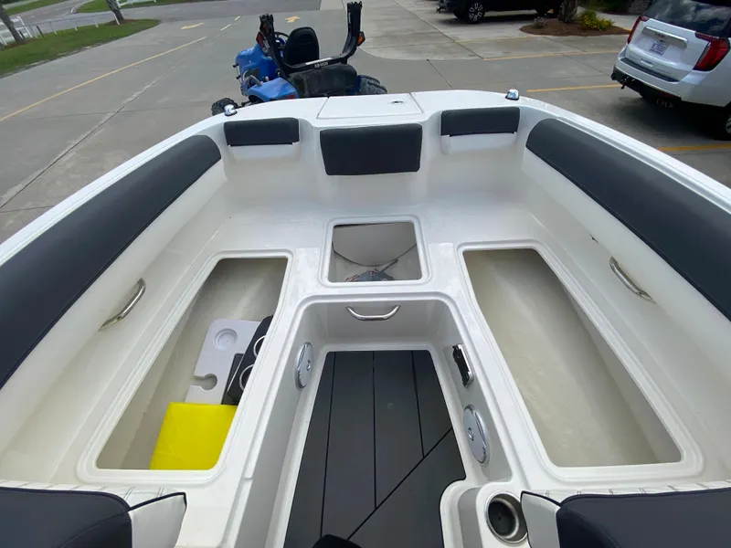 Slide: The Image of 2022 Bayliner DX2000 boat interior with storage compartments and seating. - 26