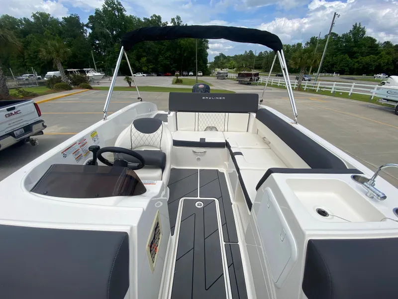Slide: The Image of 2022 Bayliner DX2000 boat interior with seating, steering wheel, and canopy. - 14
