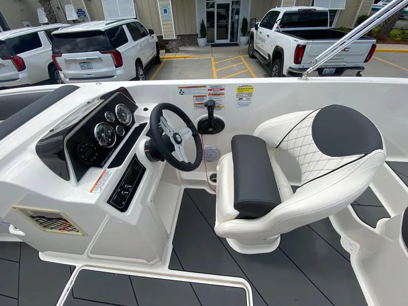 Slide: The Image of 2022 Bayliner DX2000 boat cockpit with steering wheel and captain's chair. - 15