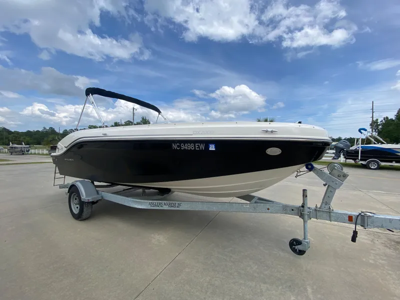 Slide: The Image of 2022 Bayliner DX2000 boat on a trailer under a partly cloudy sky. - 4