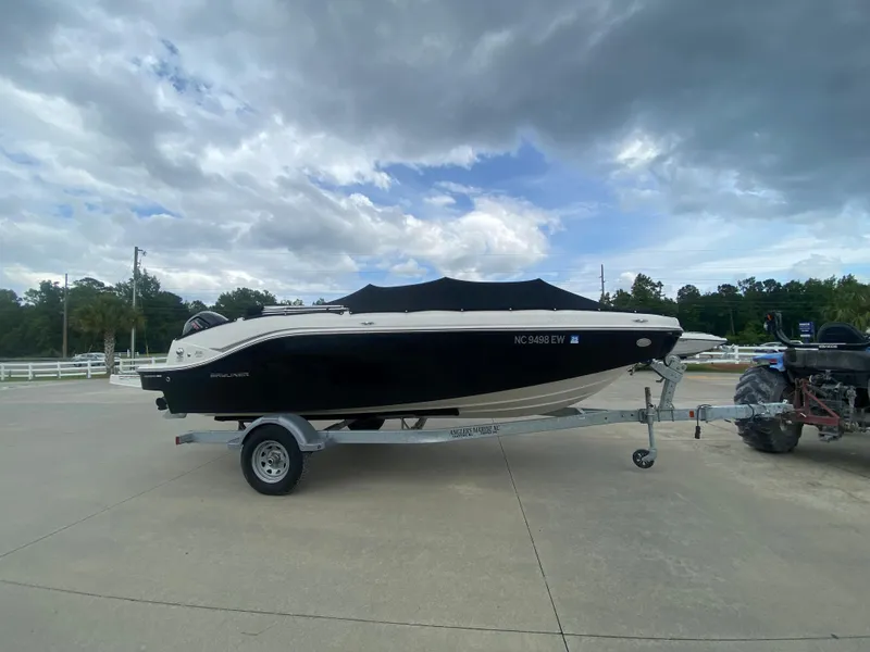 Slide: The Image of 2022 Bayliner DX2000 boat on a trailer under a cloudy sky. - 8