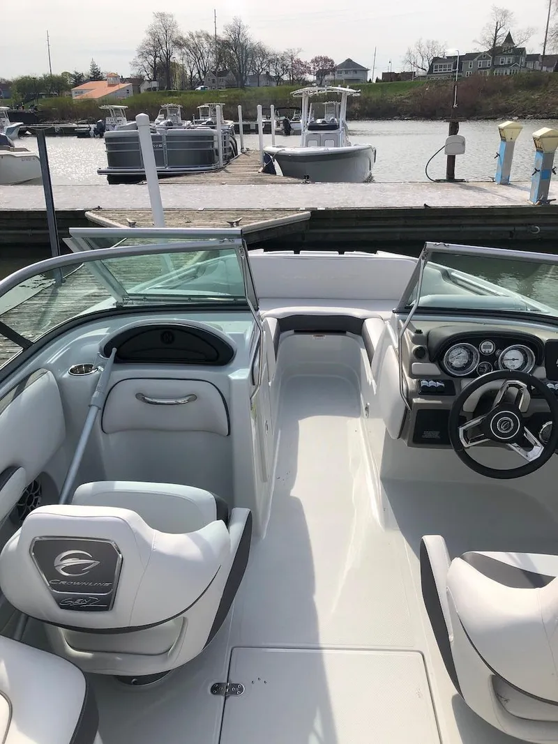 Slide: The Image of 2023 Crownline E 215 XS boat interior at a dock. - 3