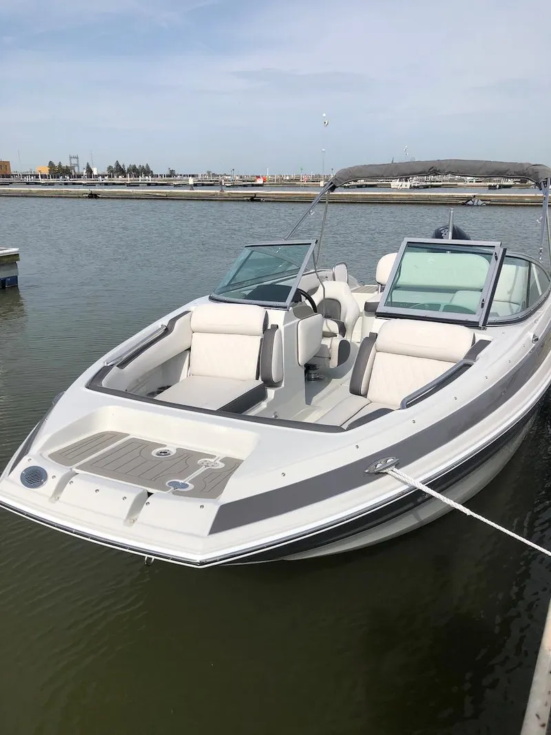 Slide: The Image of 2023 Crownline E 215 XS boat docked in a marina. - 4