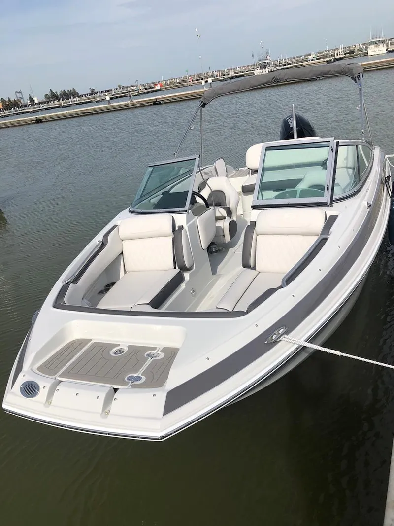 Slide: The Image of 2023 Crownline E 215 XS boat docked in a marina. - 5