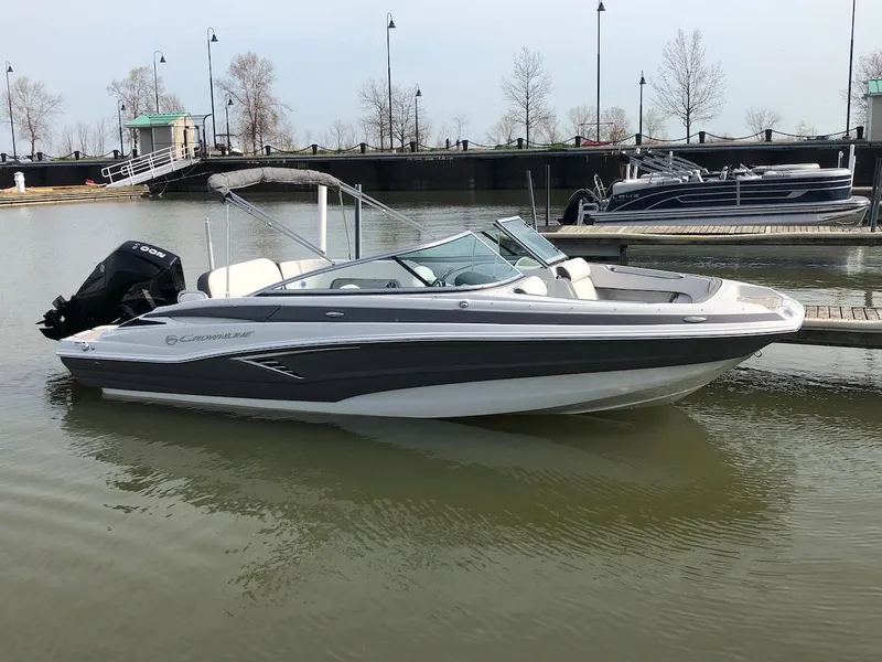 Slide: The Image of 2023 Crownline E 215 XS boat docked in a marina. - 6