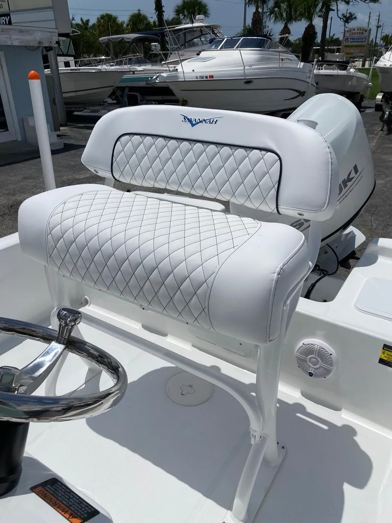 Slide: The Image of 2023 Savannah 190IS boat with white diamond-stitched seating and steering wheel. - 13