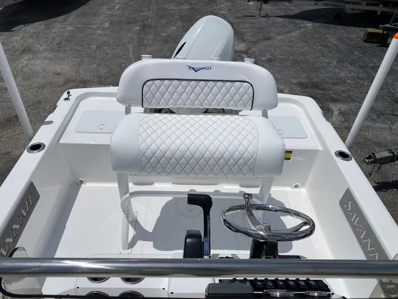 Slide: The Image of 2023 Savannah 190IS boat interior with white cushioned seating and steering wheel. - 17