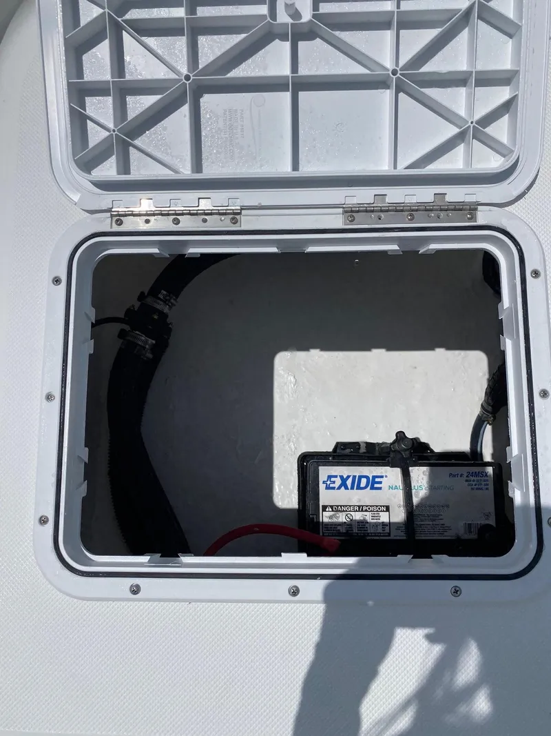 Slide: The Image of Battery compartment of a 2023 Savannah 190IS boat with Exide battery. - 19