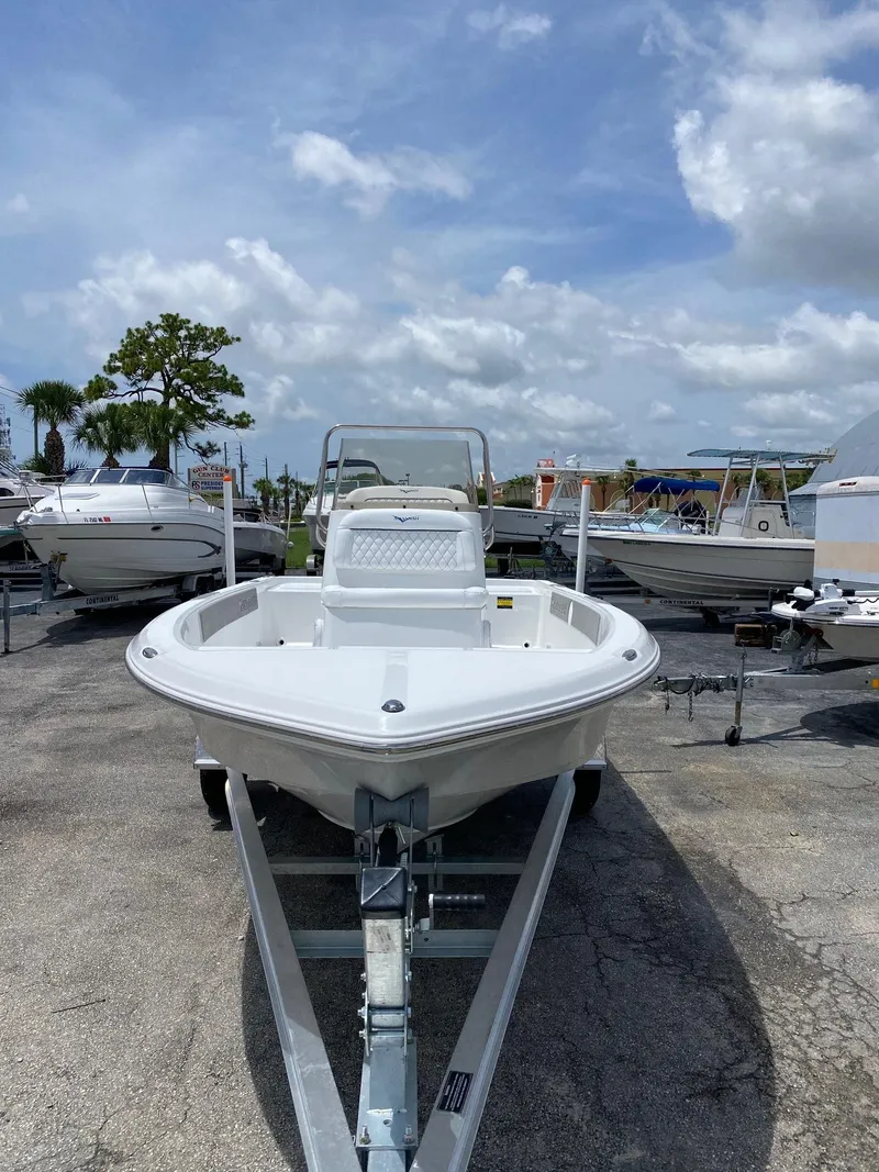 Slide: The Image of 2023 Savannah 190IS boat on trailer in marina under cloudy sky. - 2