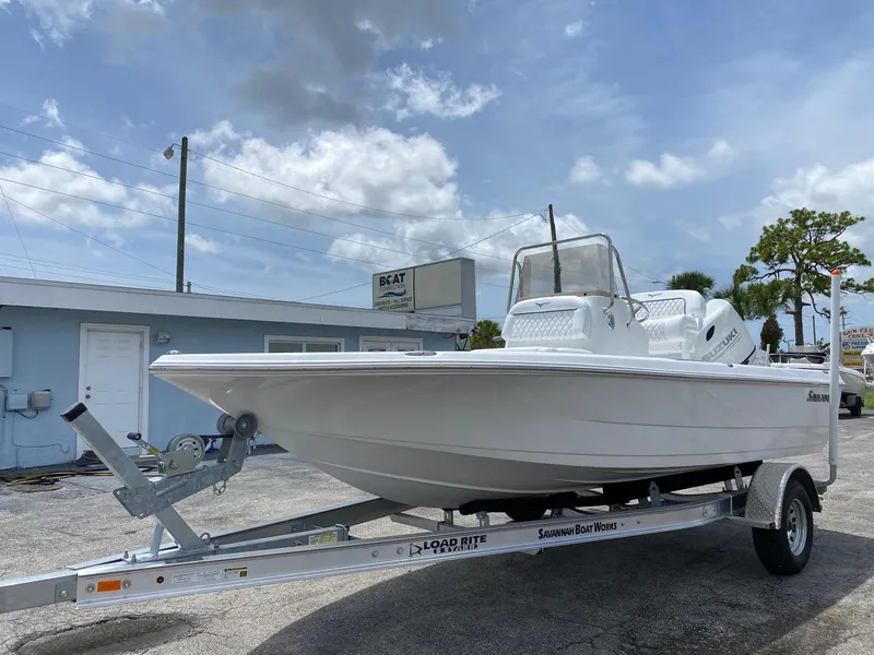 Slide: The Image of 2023 Savannah 190IS boat on trailer in parking lot under cloudy sky. - 3