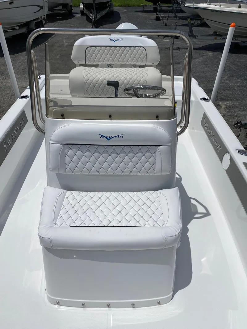 Slide: The Image of 2023 Savannah 190IS boat interior with white cushioned seating and steering console. - 9