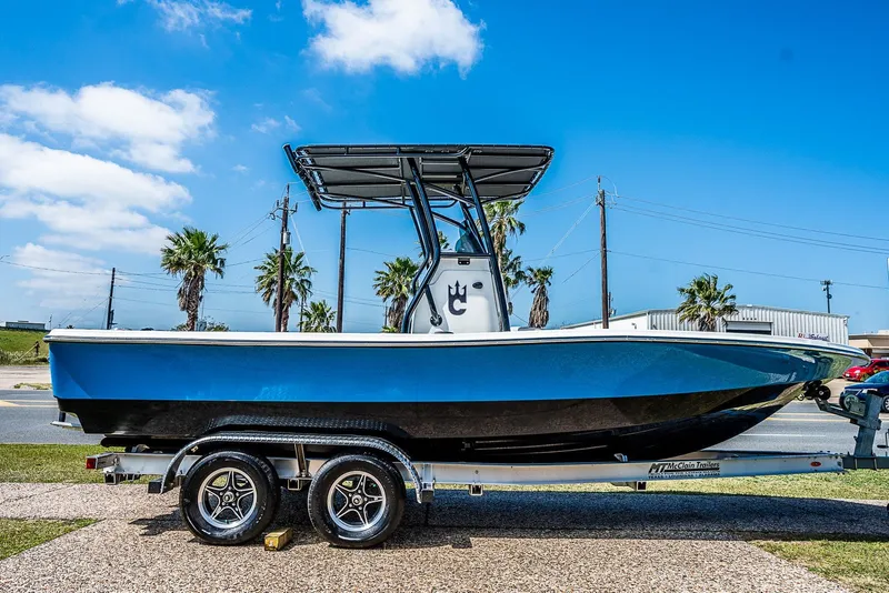 Slide: The Image of 2021 Catalyst 2300 BAY boat on trailer, blue hull, sunny day, palm trees in background. - 3