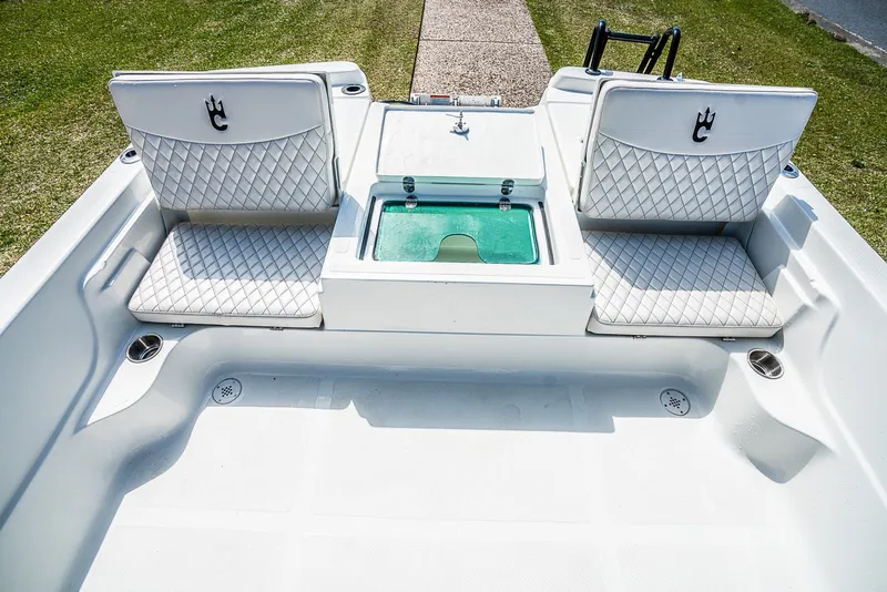 Slide: The Image of 2021 Catalyst 2300 BAY boat interior with cushioned seats and storage compartment. - 7