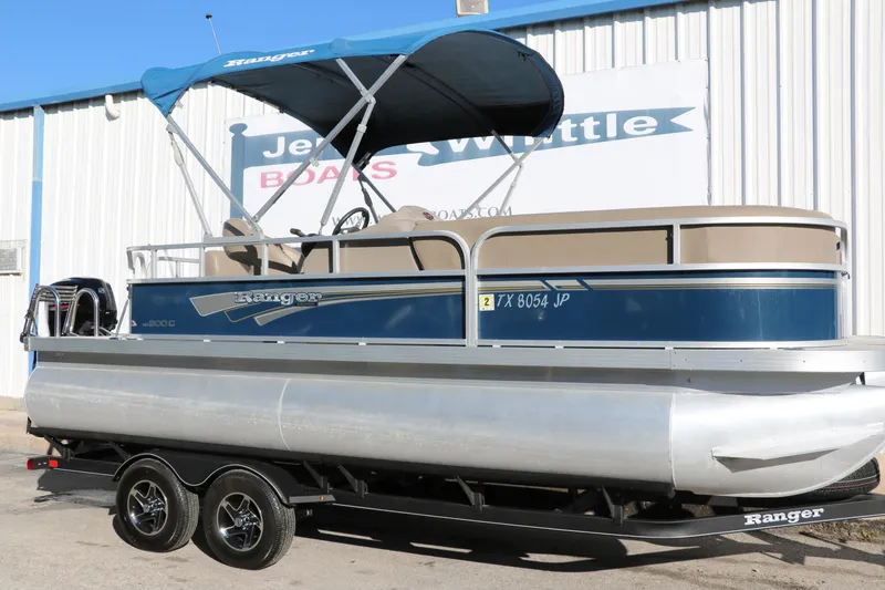 Slide: The Image of 2021 Ranger RP200C pontoon boat on trailer with blue canopy. - 0