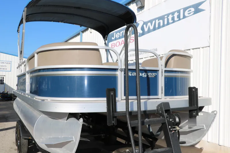 Slide: The Image of 2021 Ranger RP200C pontoon boat with blue and white exterior, displayed at dealership. - 12