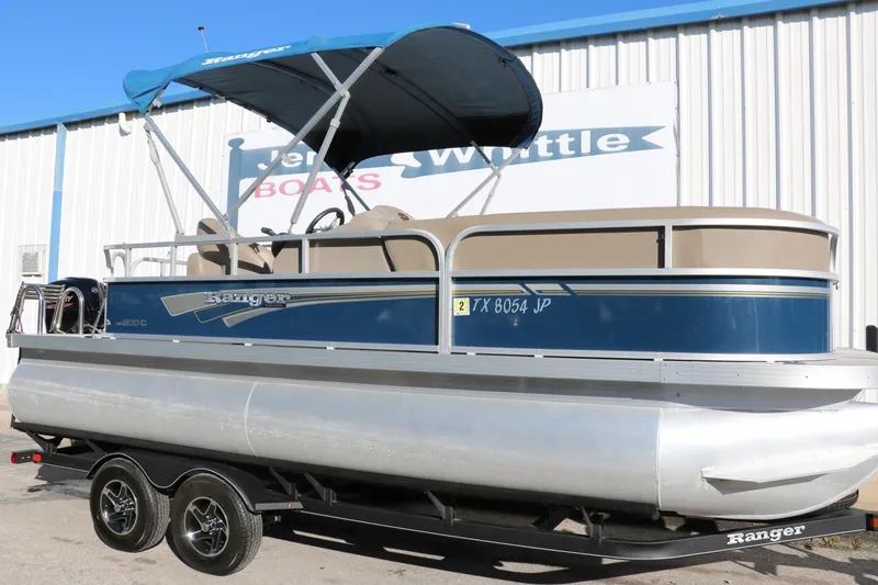 Slide: The Image of 2021 Ranger RP200C pontoon boat with blue canopy on trailer. - 16