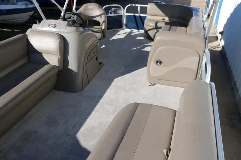 Slide: The Image of 2021 Ranger RP200C pontoon boat interior with beige seating and steering console. - 19
